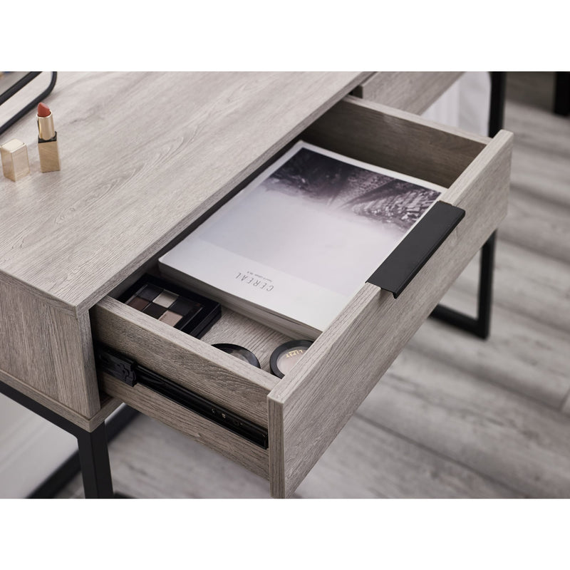 Wooden desk with an open drawer containing stationery items on a wooden floor.