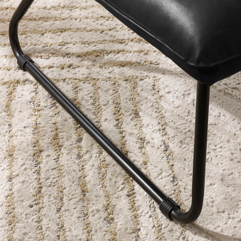 Black chair leg on a textured beige carpet