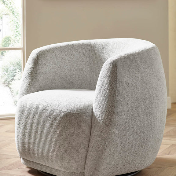Gray textured armchair in a room with a window and beige walls.
