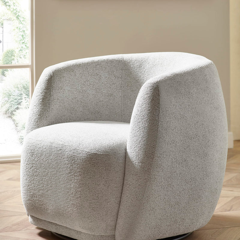 Gray textured armchair in a room with a window and beige walls.