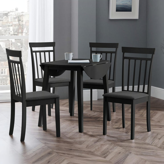 Black dining table with four chairs in a room with a window and framed picture on the wall.