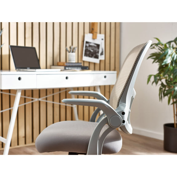 Ergonomic office chair in front of a white desk with a laptop and decor items.