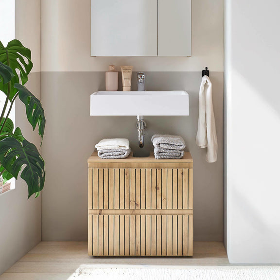 Bathroom with wooden cabinet, sink, and towels