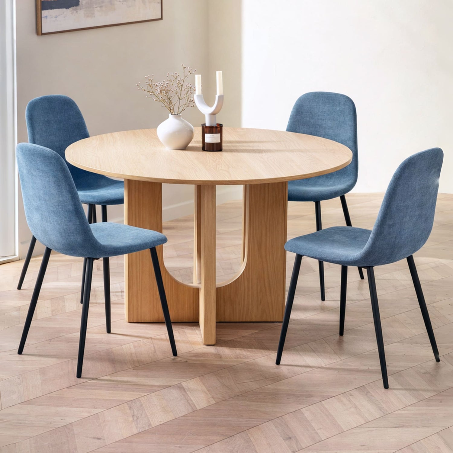 Dining room with a round wooden table and four blue chairs.