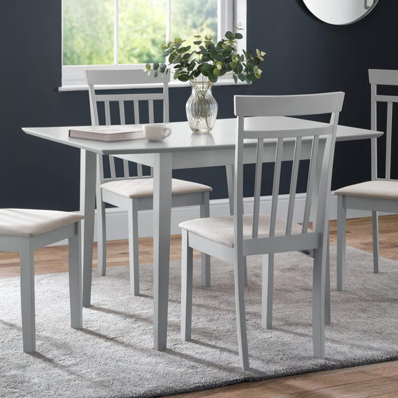 Dining room with gray table and chairs against a dark blue wall.
