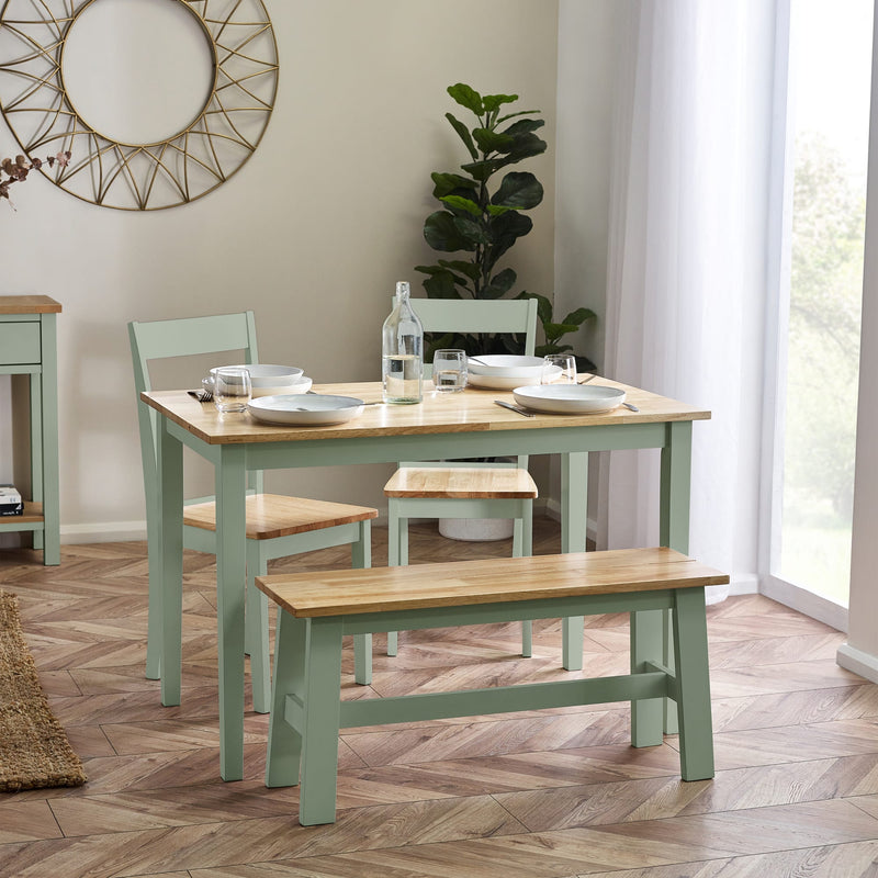 Dining room with a wooden table and chairs on a herringbone floor.