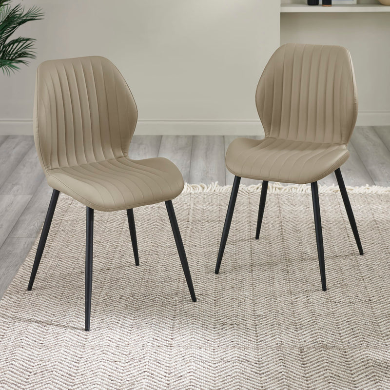 Two beige chairs with black legs on a textured rug
