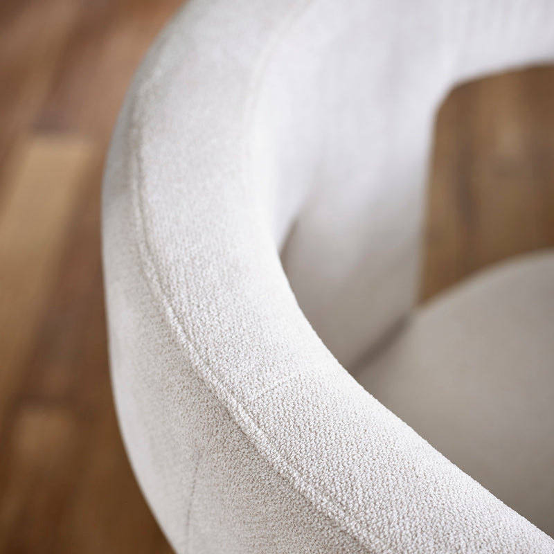 Close-up of a textured white chair with a blurred wooden floor background