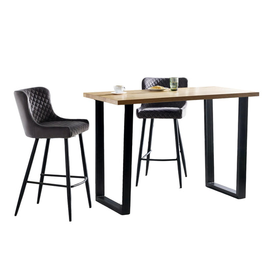 Wooden dining table with black metal legs and two bar stools on a white background