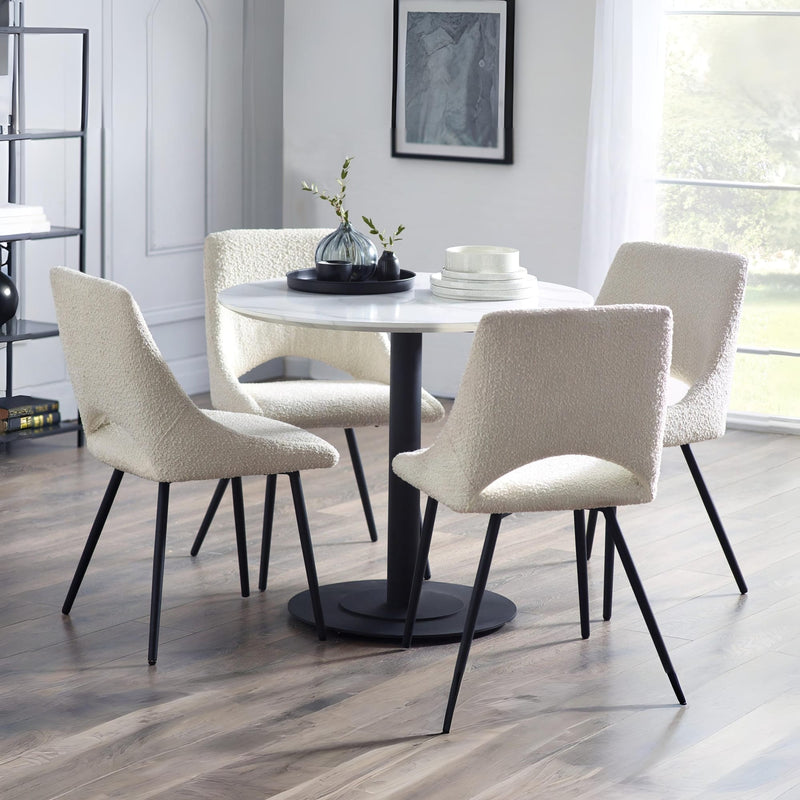 Dining room with a round table and four chairs in a modern interior setting.