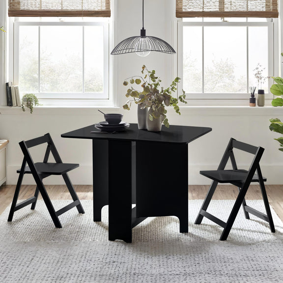 Black dining table with two chairs in a bright room with large windows.