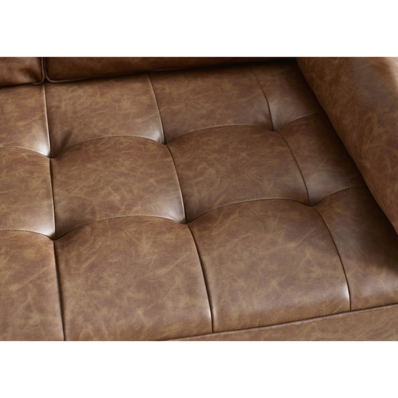 Close-up of a brown leather sofa with tufted design