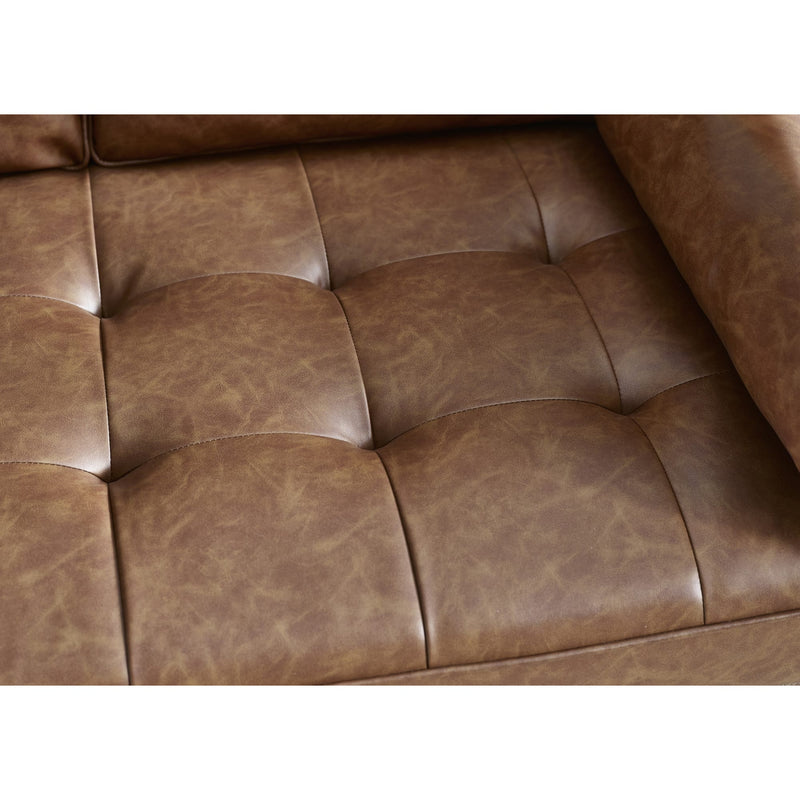 Close-up of a brown leather sofa with tufted design