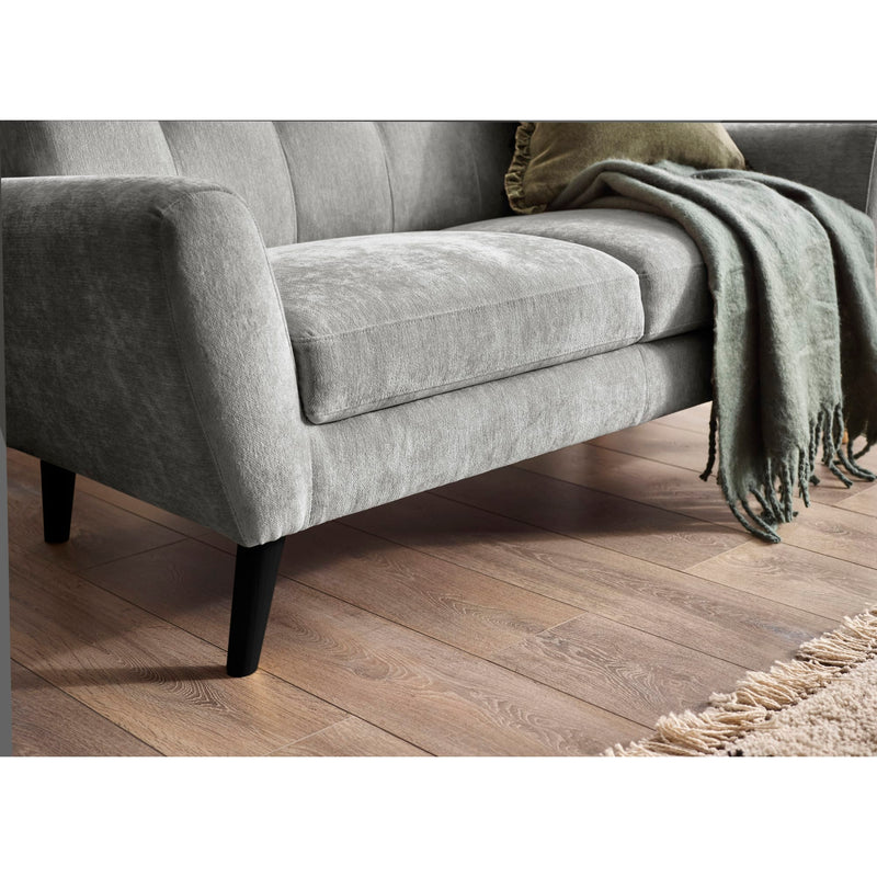 Gray sofa with a green blanket on a wooden floor