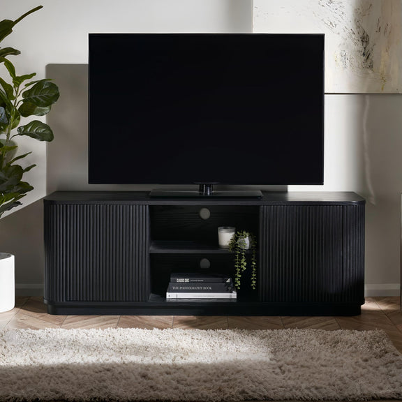 Black TV stand with a television on top in a room with a plant and rug.