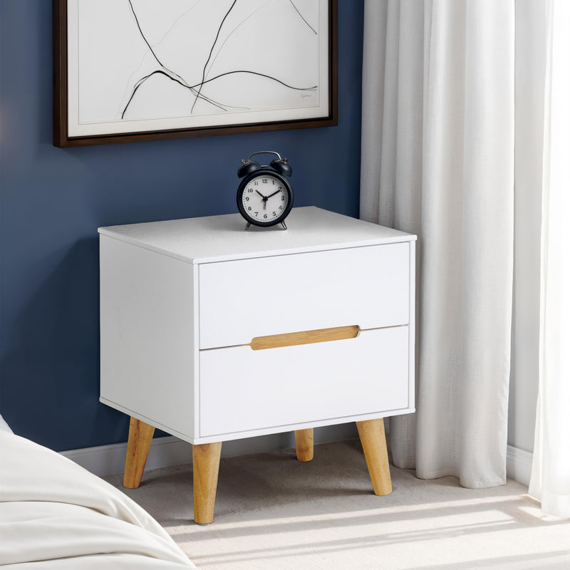 White nightstand with wooden legs and a black clock on top, against a blue wall with a framed picture.