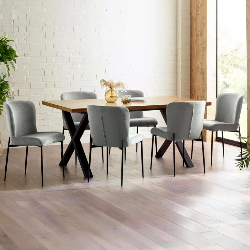 Dining room with a wooden table and gray chairs in a well-lit room.