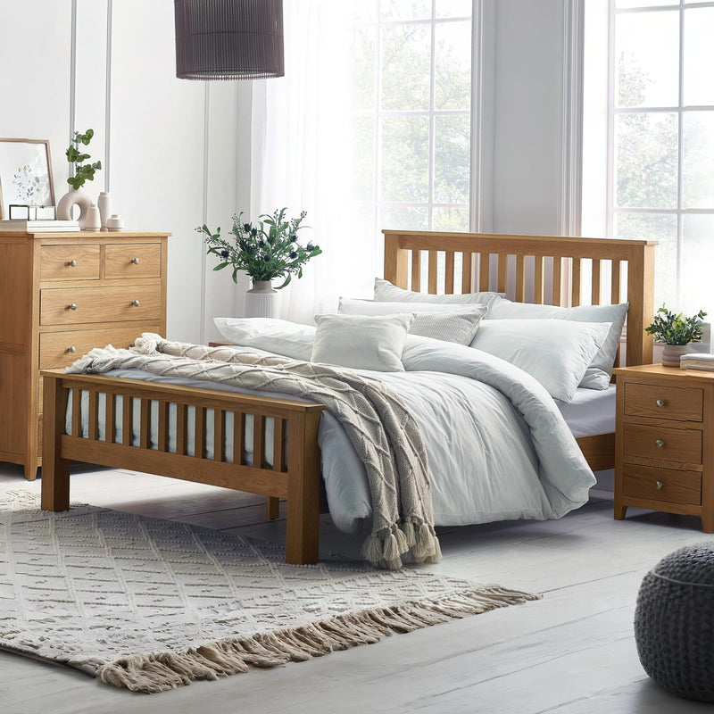 Wooden bed with white bedding in a bright bedroom setting