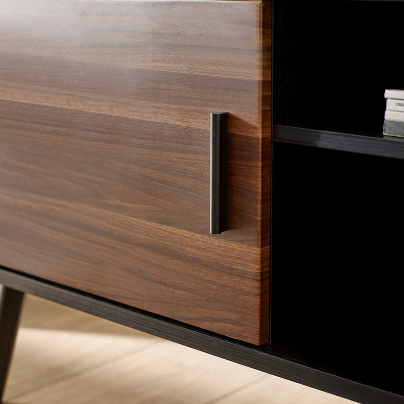 Wooden cabinet with a metallic handle on a light wood floor.