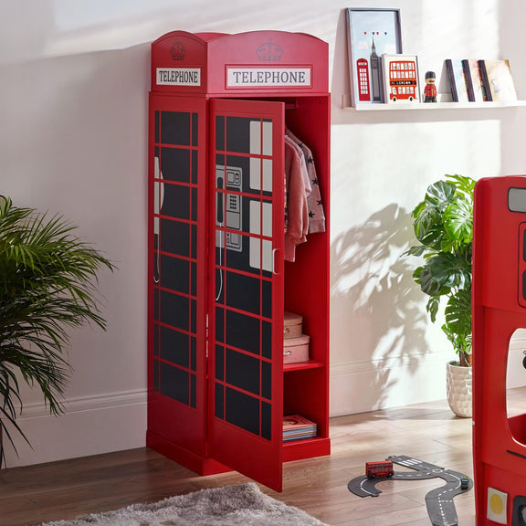 Red telephone booth-shaped bookshelf in a room with plants and a shelf.