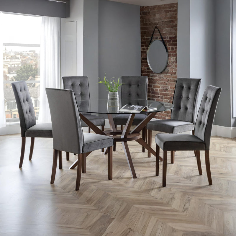 Dining room with a glass table and gray chairs in a modern interior setting.