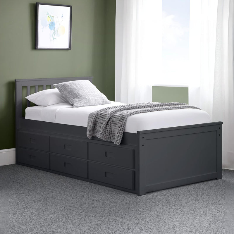 Black bed frame with storage drawers in a room with green walls and white curtains.