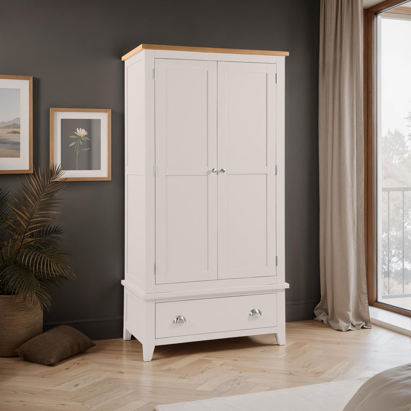 White wardrobe with wooden top in a room with dark walls, framed pictures, and a window.