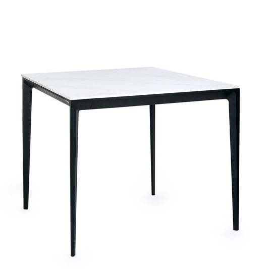 Square table with black legs and white top on a white background