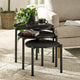 Set of three black nesting tables in a living room setting with decor items on top.