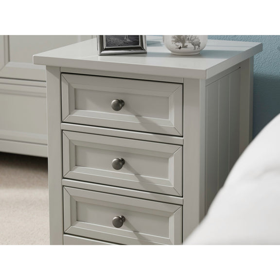 Gray nightstand with three drawers in a bedroom setting