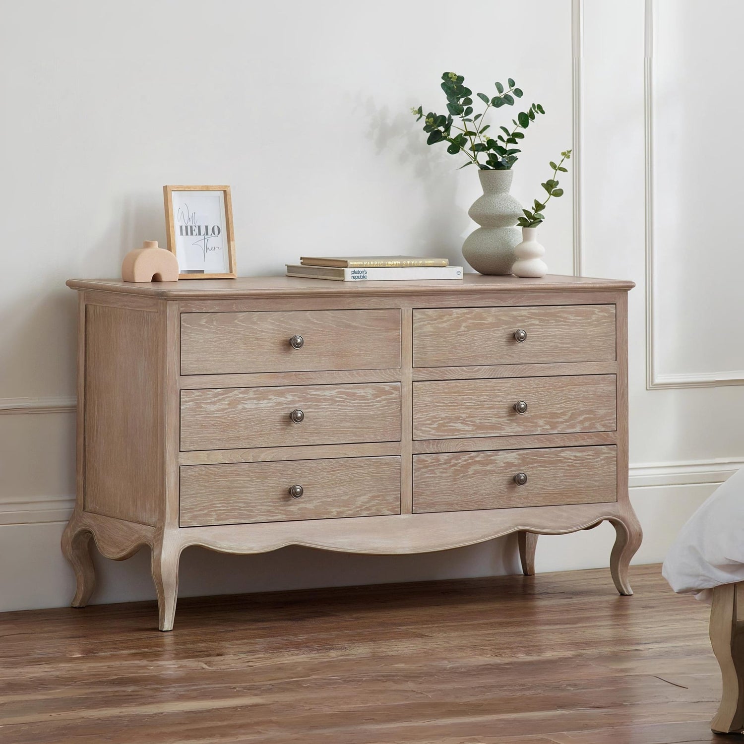 Wooden dresser with decorative items in a room setting