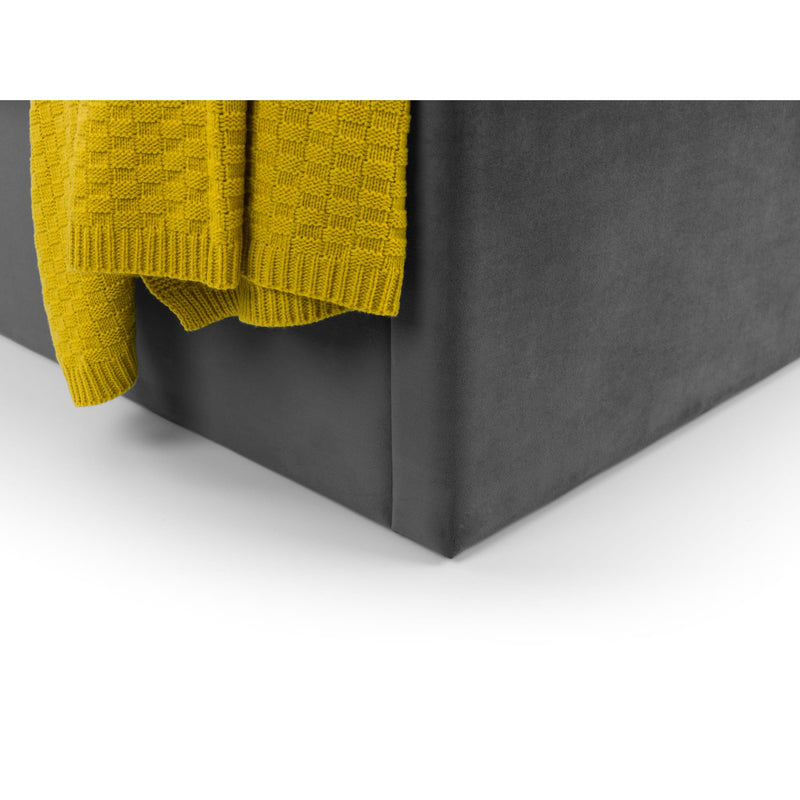 Yellow knitted blanket draped over a dark gray box on a white background
