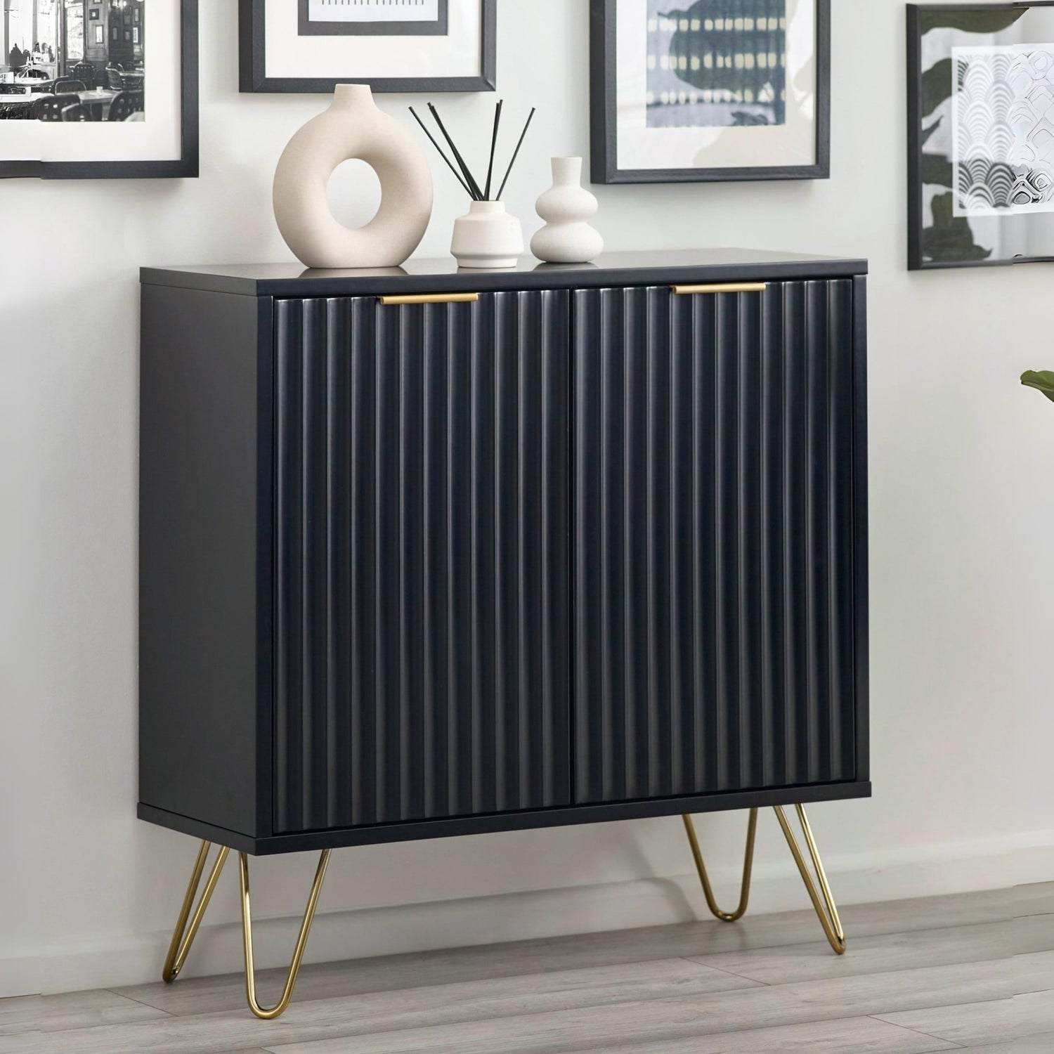 Black ribbed cabinet with gold legs in a room setting