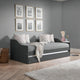 Gray sofa bed in a room with gray walls, framed pictures, and decorative items.