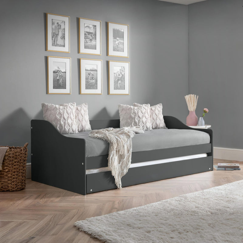 Gray sofa bed in a room with gray walls, framed pictures, and decorative items.