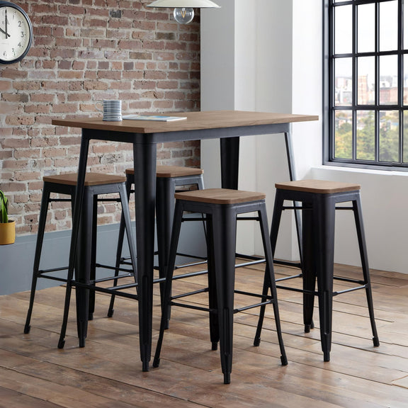 Bar height table with four stools in a room with brick wall and window.