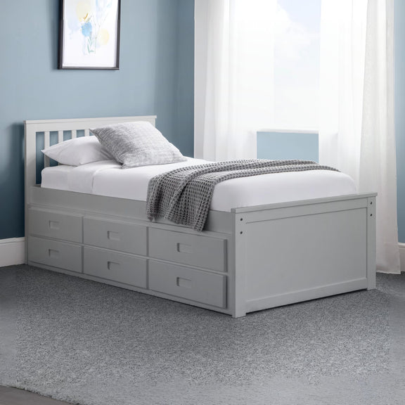 Gray bed with storage drawers in a room with blue walls and a window.