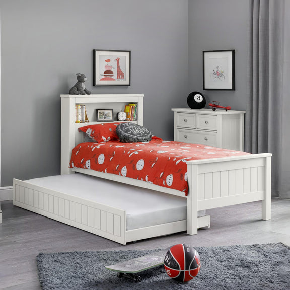 White bed with red bedding in a room with gray walls and a rug.