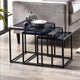 Set of black nesting tables with decorative items on a wooden floor.