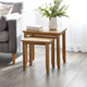 Wooden side table with a vase of flowers next to a gray sofa in a living room.