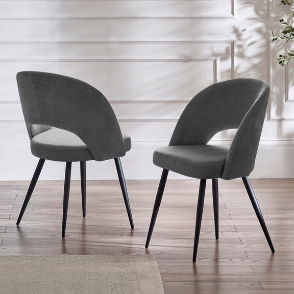 Two gray chairs with black legs on a wooden floor.