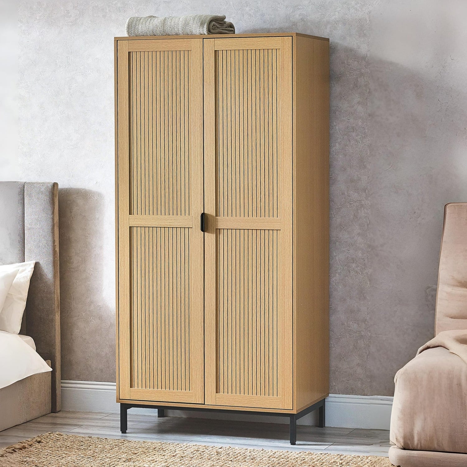 Beige wardrobe in a bedroom setting with a bed and sofa.