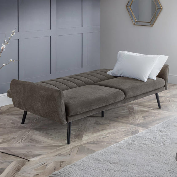 Gray sofa bed in a room with a gray wall and wooden floor.