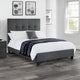 Gray upholstered bed with white bedding in a bedroom setting.