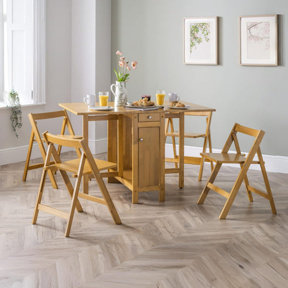 Wooden dining set with table and chairs in a room with light gray walls and a window.