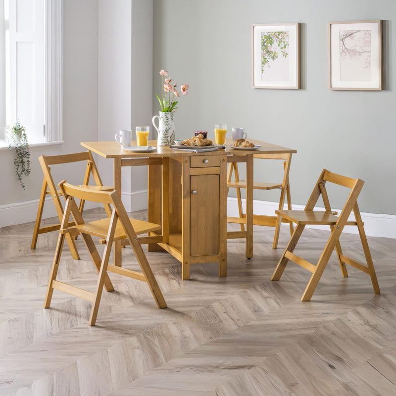 Wooden dining set with table and chairs in a room with light gray walls and a window.