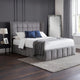 Gray upholstered bed with white bedding in a bedroom setting.
