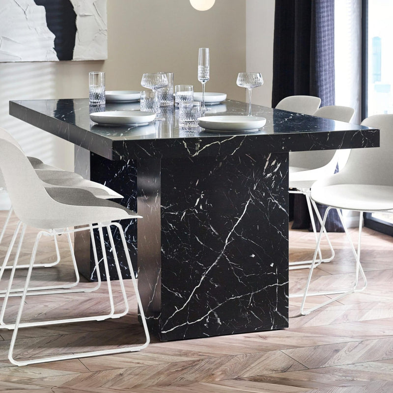 Dining room with a black marble table and white chairs.