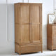 Wooden wardrobe with two doors and a drawer in a room setting.