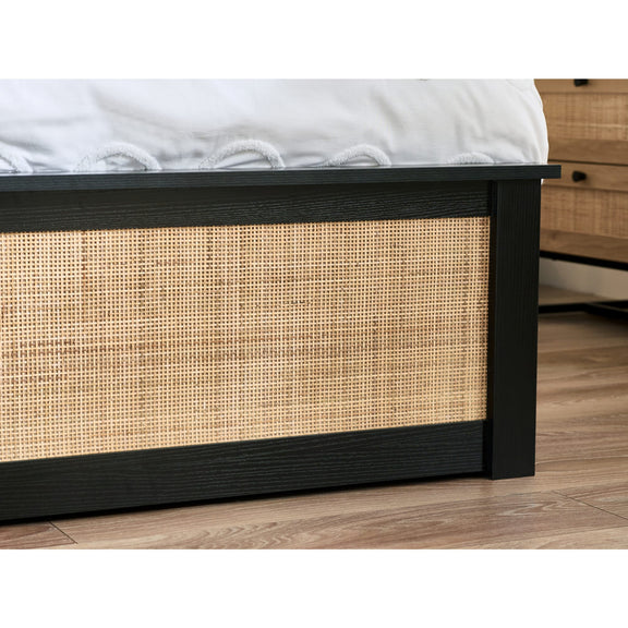 Bed with wicker side panel on a wooden floor